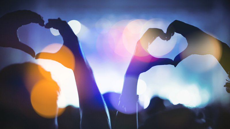 Hands creating heart shapes at a concert